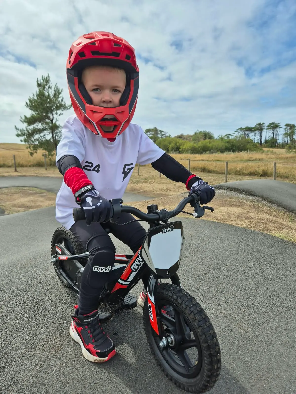 Young rider in a full-face helmet on a Revvi 12 electric balance bike