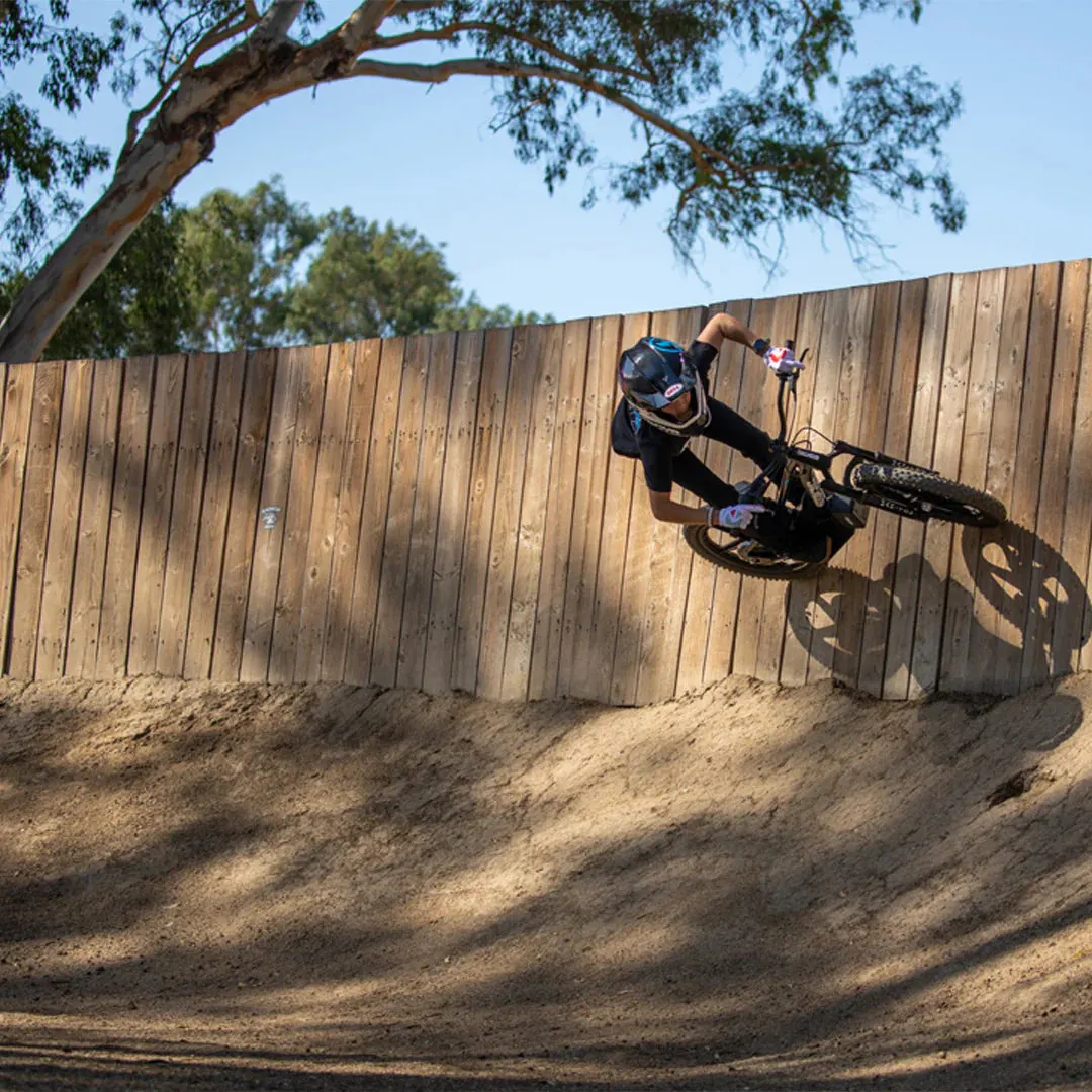 Young rider pushing a premium kids electric bike off road
